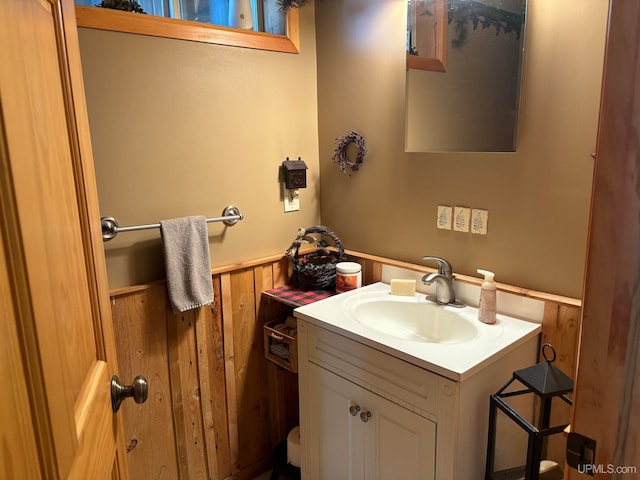 bathroom featuring wood walls and vanity