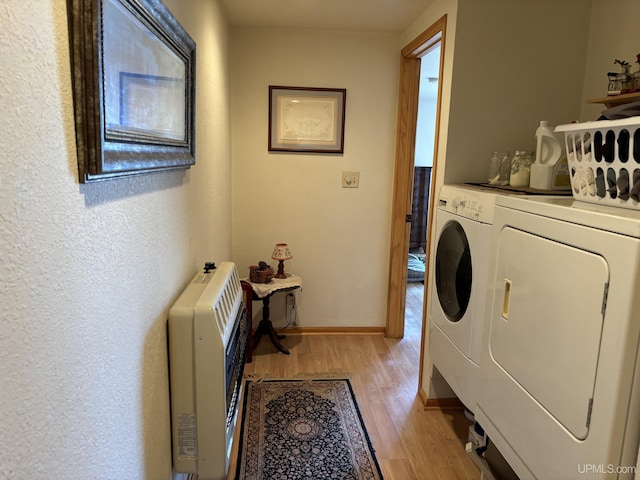 14998 N Superior Rd, Houghton, MI 49931 - laundry room featuring heating unit, separate washer and dryer, light wood-type flooring, baseboards, and a textured wall
