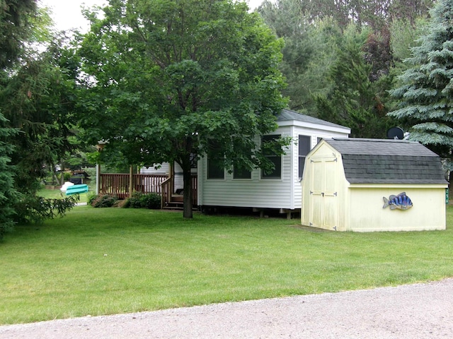 view of yard featuring an outbuilding, a deck, and a shed