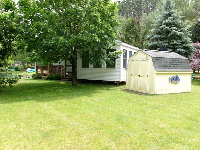 view of yard featuring an outbuilding, a storage unit, and a deck