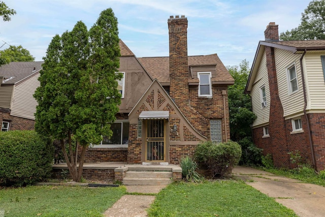 tudor-style house featuring a front yard