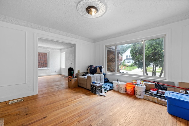 interior space featuring light wood-type flooring and a textured ceiling