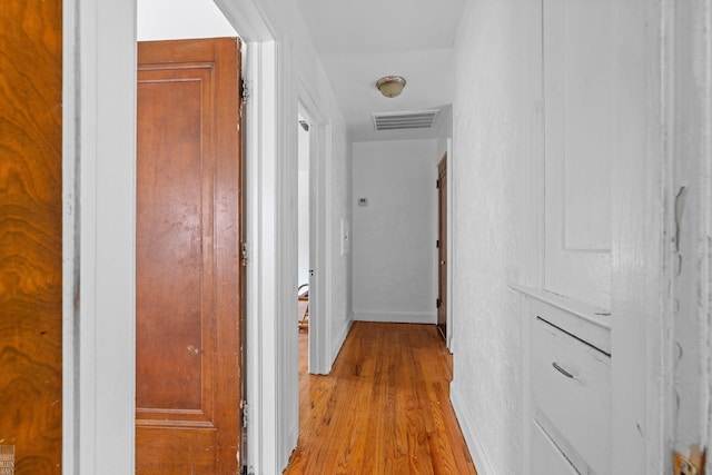 corridor with light hardwood / wood-style floors