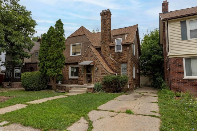 tudor home featuring a front lawn