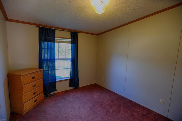 carpeted spare room featuring a textured ceiling and ornamental molding