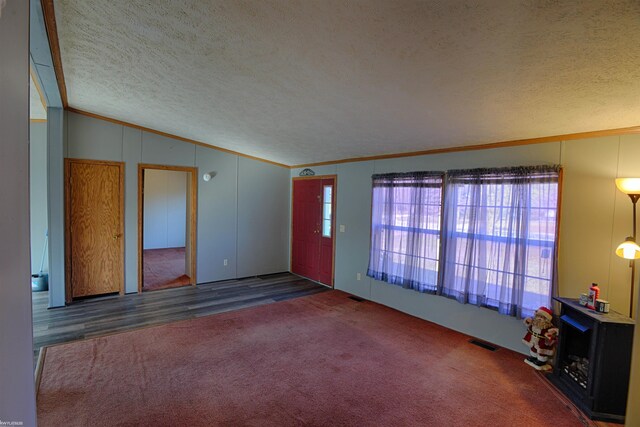 carpeted spare room with ornamental molding, a textured ceiling, and lofted ceiling