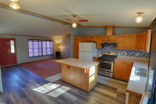 kitchen with a kitchen island, vaulted ceiling, gas range, light hardwood / wood-style floors, and white fridge