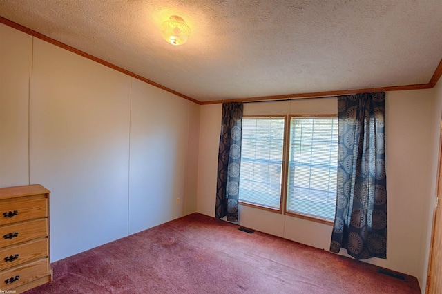 carpeted empty room featuring ornamental molding and a textured ceiling