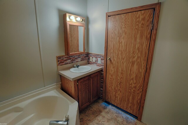 bathroom with a bathtub, tile patterned flooring, backsplash, and vanity