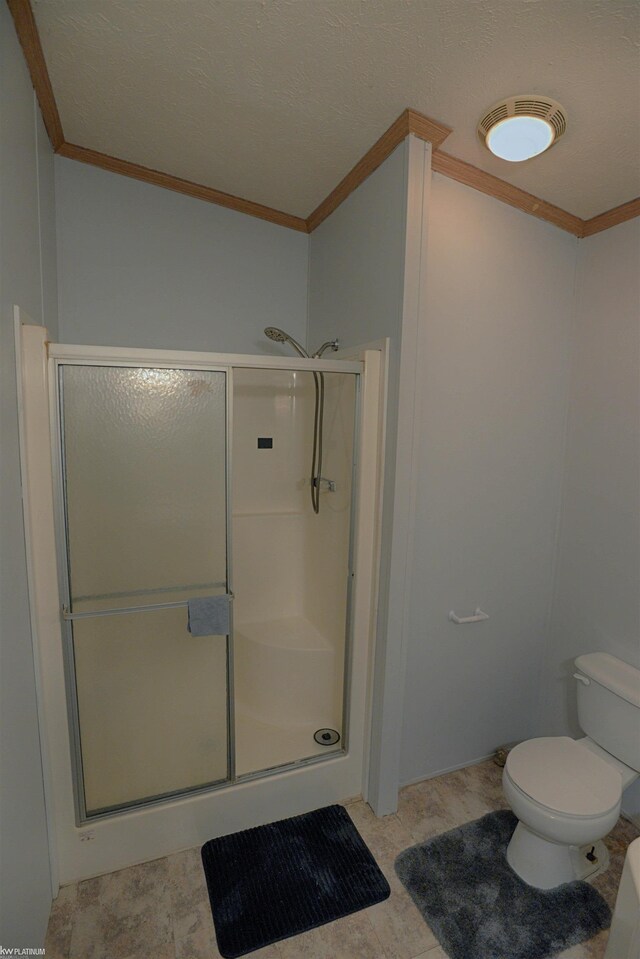 bathroom featuring a shower with shower door, toilet, tile patterned flooring, and ornamental molding