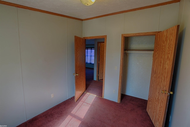 unfurnished bedroom featuring ornamental molding, a closet, a textured ceiling, and light colored carpet