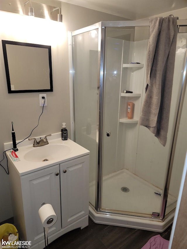 bathroom featuring a shower with shower door, vanity, and wood-type flooring