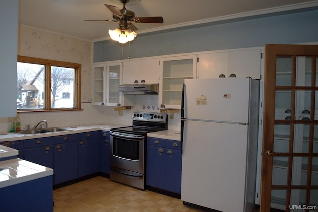 kitchen with freestanding refrigerator, electric range, blue cabinetry, under cabinet range hood, and a sink