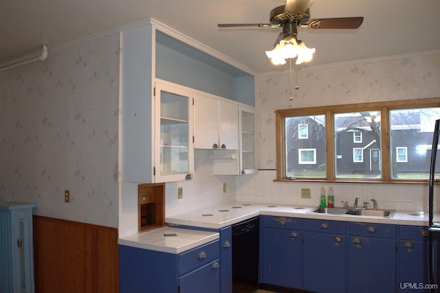 kitchen featuring wallpapered walls, blue cabinets, light countertops, dishwasher, and a sink