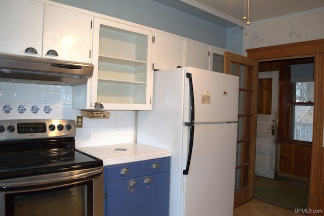 kitchen featuring freestanding refrigerator, stainless steel range with electric stovetop, under cabinet range hood, blue cabinets, and backsplash