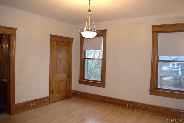 unfurnished room featuring light wood-type flooring, a healthy amount of sunlight, and baseboards