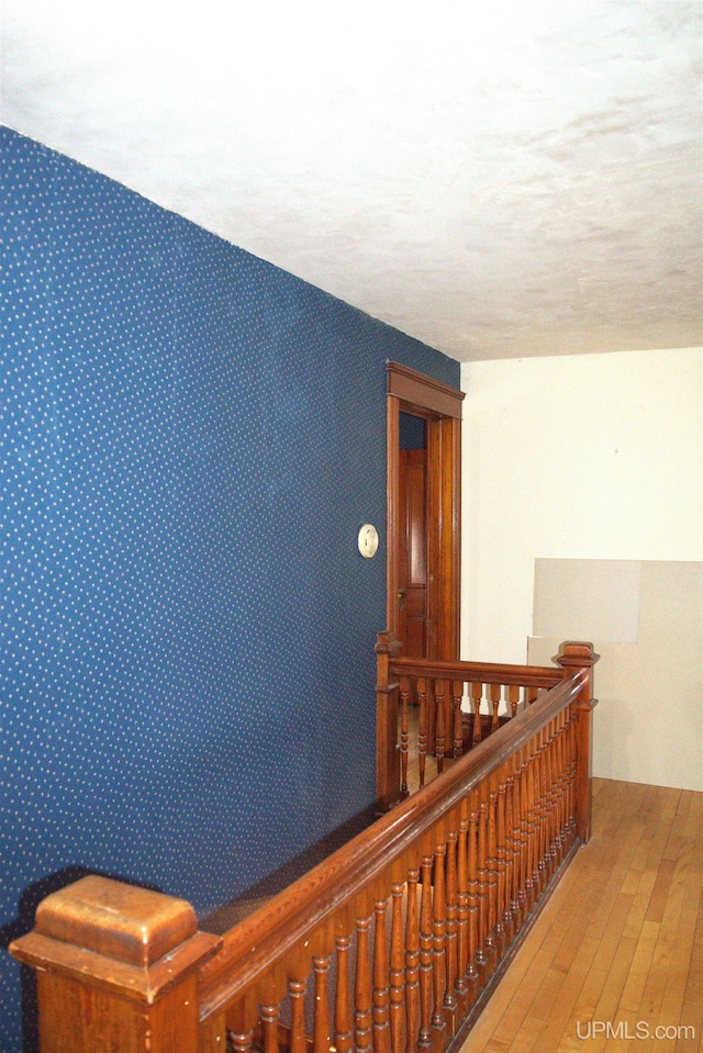 corridor featuring an upstairs landing and hardwood / wood-style flooring