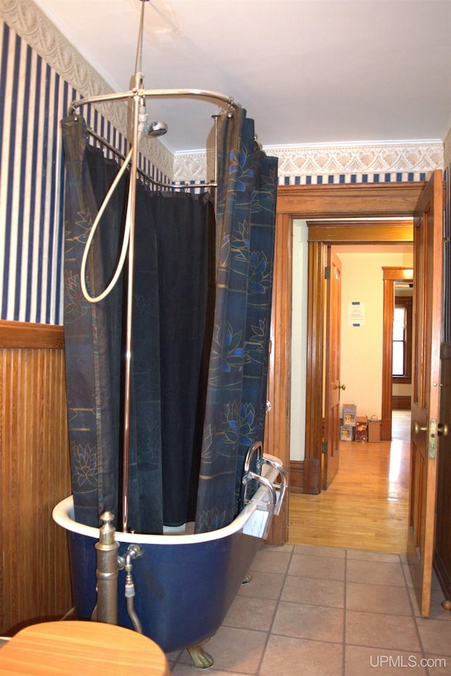 bathroom featuring a bath, wallpapered walls, and a shower with curtain