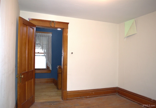 unfurnished room with baseboards and wood finished floors