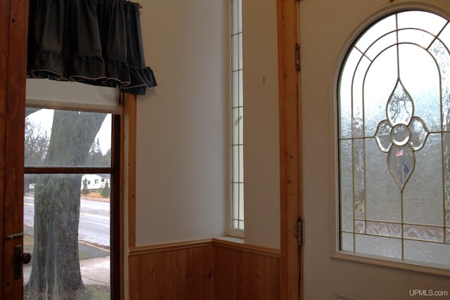 foyer entrance with wood walls and wainscoting