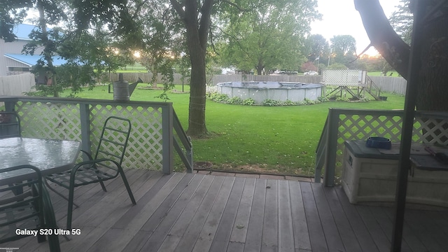 wooden terrace featuring a fenced in pool and a yard