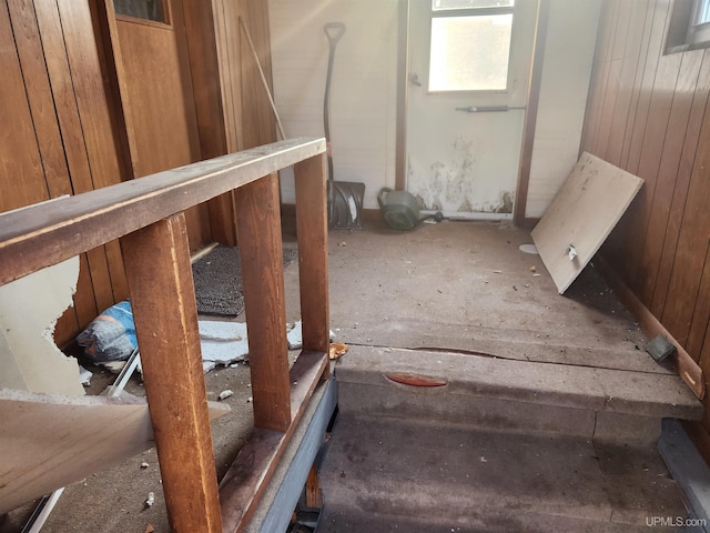 stairs featuring wood walls