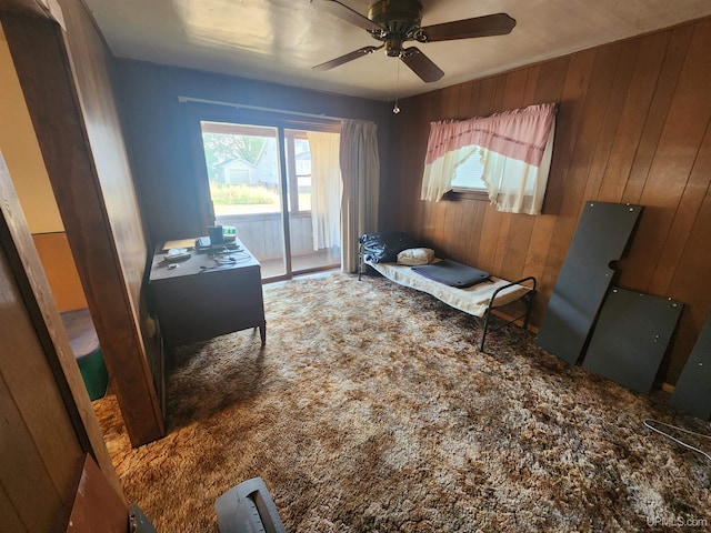 interior space featuring wooden walls, ceiling fan, and a healthy amount of sunlight