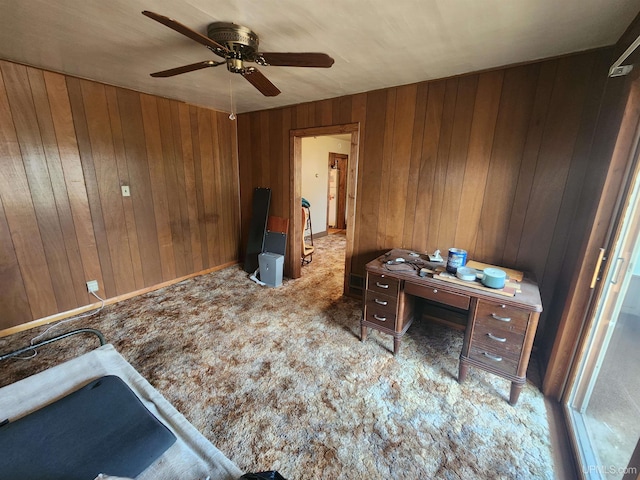 carpeted bedroom with ceiling fan and wood walls