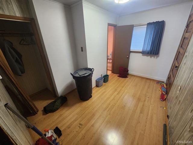 bedroom with crown molding, light hardwood / wood-style flooring, and a closet