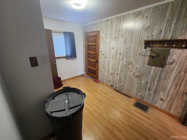 interior space featuring light wood-type flooring and wood walls