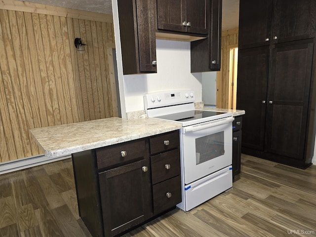 kitchen featuring light countertops, white range with electric cooktop, wood finished floors, and dark brown cabinetry