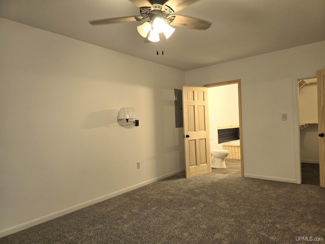 unfurnished bedroom featuring ensuite bathroom, carpet flooring, a walk in closet, and baseboards