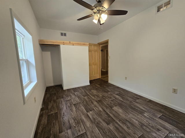 unfurnished bedroom with dark wood-style floors, visible vents, ceiling fan, and baseboards