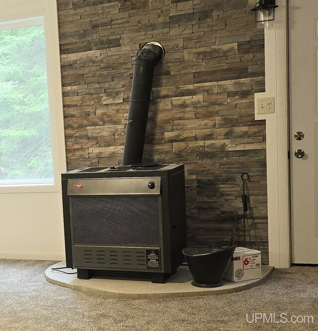 unfurnished living room featuring a textured ceiling, ceiling fan, a wood stove, and carpet