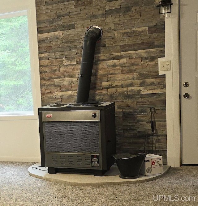 room details with a wood stove, heating unit, and carpet flooring