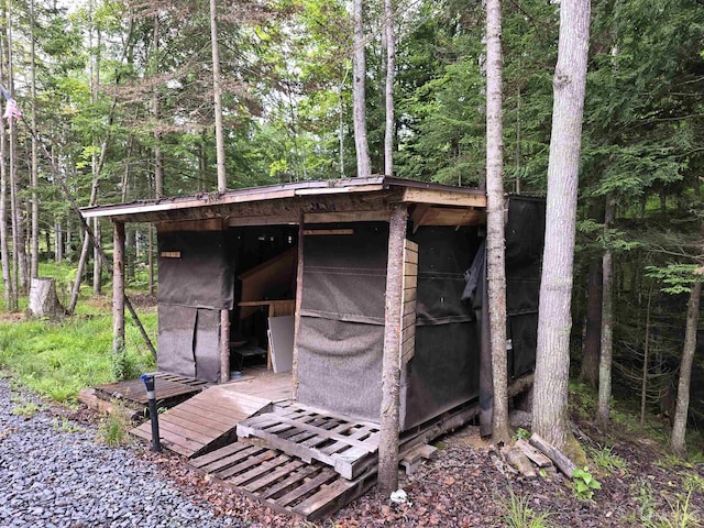 view of outbuilding featuring a forest view and an outdoor structure