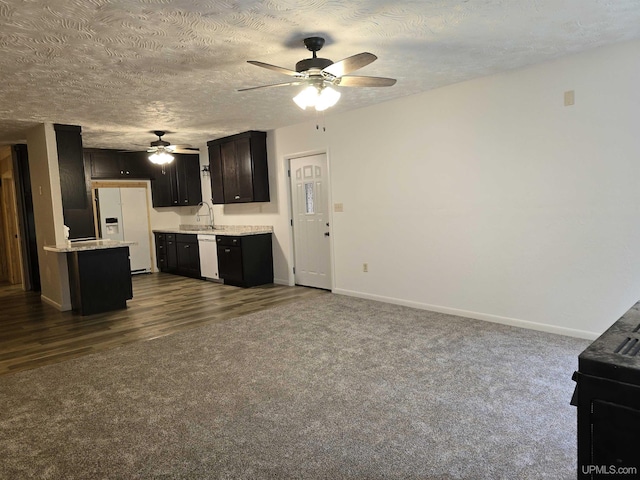 unfurnished living room with a ceiling fan, dark colored carpet, a textured ceiling, and baseboards