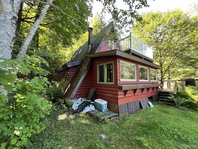 view of home's exterior featuring a lawn and a deck