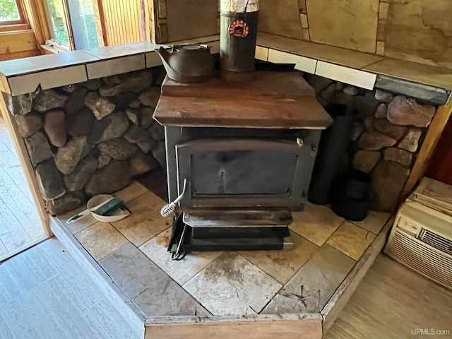 interior details with hardwood / wood-style floors and a wood stove