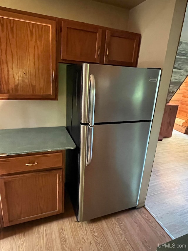 kitchen with stainless steel refrigerator and light hardwood / wood-style floors