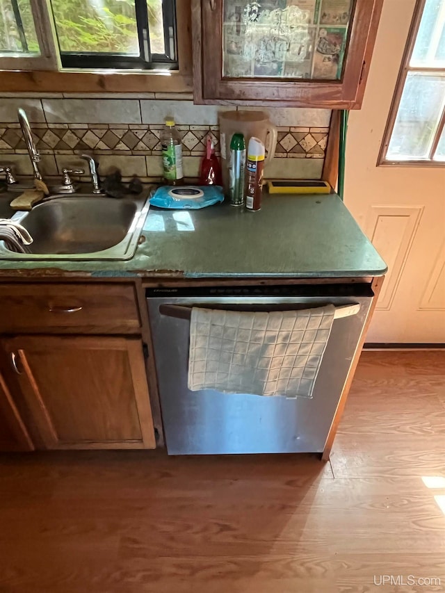 interior space with light wood-type flooring, backsplash, and sink