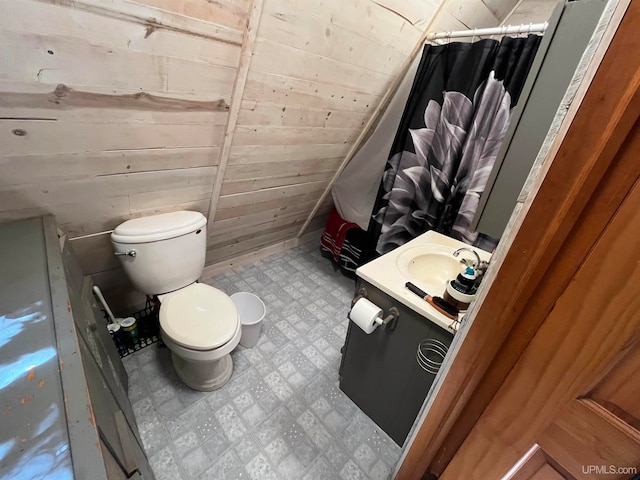 bathroom with wood walls, vanity, toilet, and a shower with shower curtain