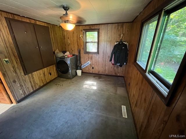 interior space with ceiling fan, wooden walls, and washer / dryer