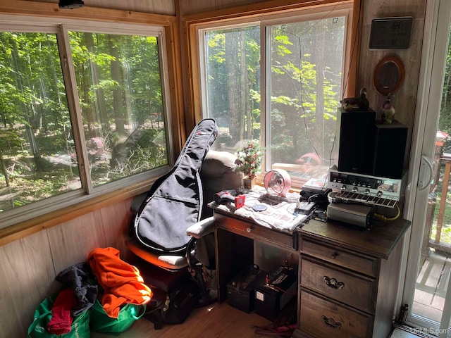 office area with wooden walls, hardwood / wood-style floors, and a healthy amount of sunlight