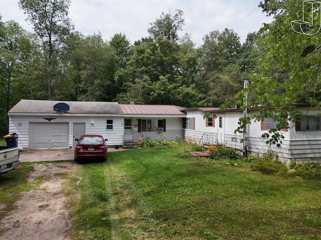 back of property featuring a garage and a yard