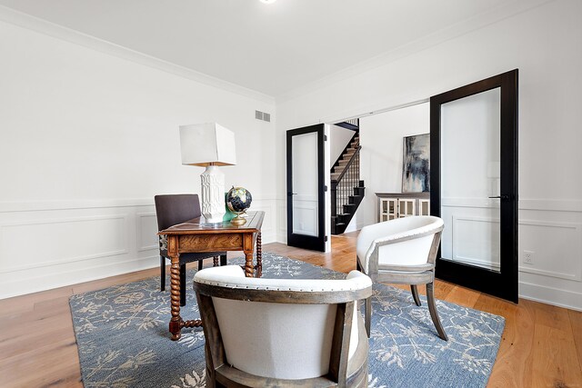 living area featuring light hardwood / wood-style floors and ornamental molding