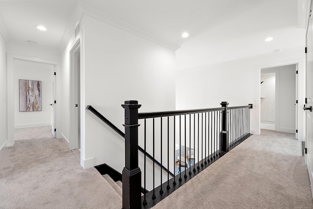 hallway with crown molding and light colored carpet