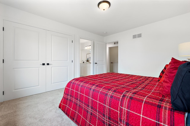 carpeted bedroom with a closet and ensuite bathroom