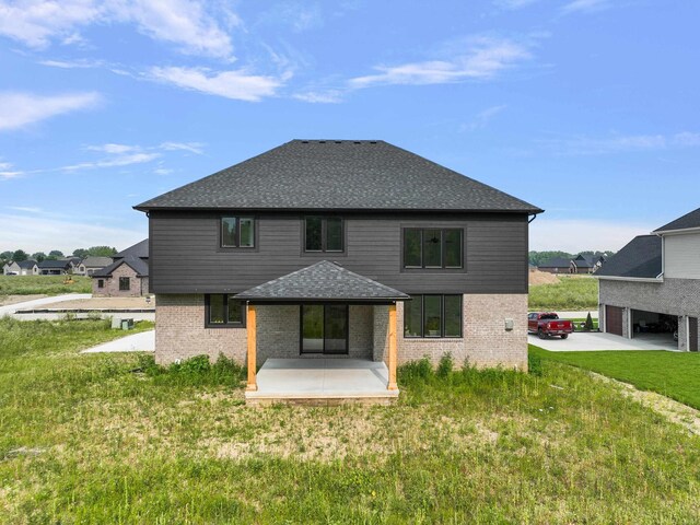 rear view of house featuring a lawn and a patio area