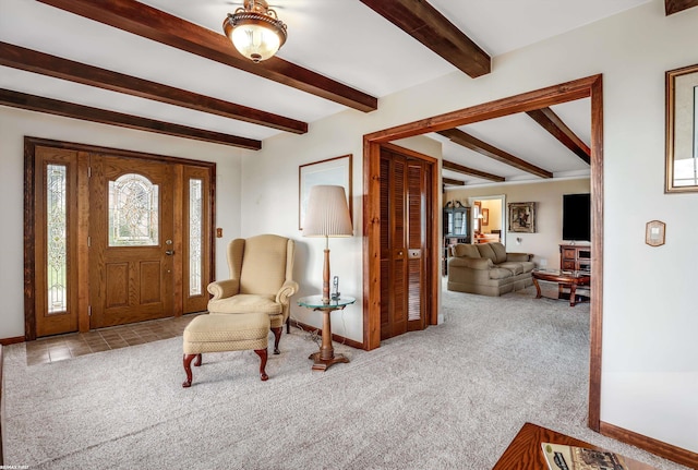 foyer featuring baseboards, beam ceiling, and light colored carpet